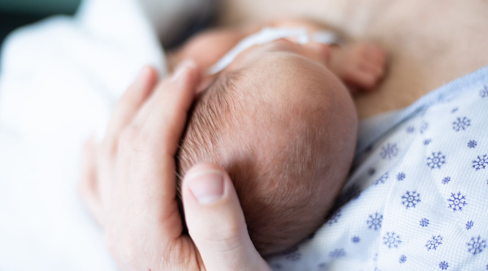 A mother holding her newborn child’s head