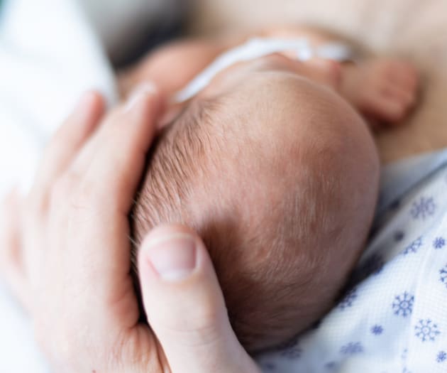 A mother holding her newborn child’s head